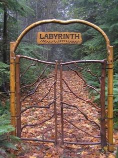 a wooden gate with a sign that says labyrrinth on it in the woods