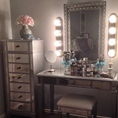 a vanity with stool, mirror and lights on it's sides in a room