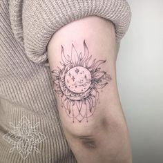 a woman with a sun and moon tattoo on her arm