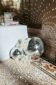 the table is set up with silver balloons and confetti on top of it