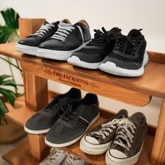 three pairs of sneakers are sitting on a shelf