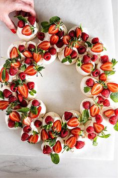 a cake decorated with strawberries and mint leaves