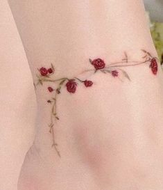 a woman's foot with red roses on it and the bottom part of her leg