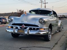 an old car is parked on the side of the road