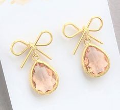 Bow Earrings, Bridesmaid Proposal, Bridesmaid Bow Earrings, Bow Crystal Earrings, Blush Bridesmaids Earrings, Peach Bridesmaid The idyllic bows compliment dangling teardrop crystals in this perfect pair of earrings for your Bridesmaids gift. Ideal for the day of your wedding or bridesmaids proposal.The total earring measures almost 1". The crystal color pictured is Blush Peach. Several other options are available from the drop down menu.* This listing is for the Bow and Crystal earrings in the f Pink Dainty Earrings For Formal Occasions, Dainty Pink Earrings For Formal Occasions, Cute Pink Earrings For Wedding, Cute Pink Wedding Earrings, Pink Earrings For Bridesmaids, Blush Drop Earrings For Gift, Pink Earrings For Bridesmaid Gift, Cute Pink Bow Earrings For Party, Yellow Gold Bow Earrings For Wedding