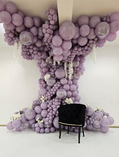 a chair sitting in front of a bunch of balloons