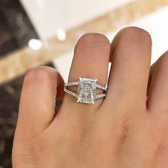 a woman's hand with a diamond ring on top of her finger and an engagement band