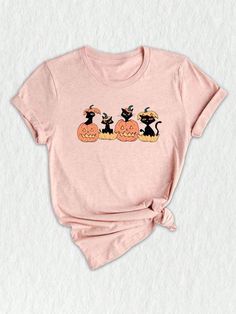 a pink t - shirt with two cats sitting on pumpkins and one is wearing a black cat