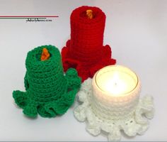 two crocheted candles sitting next to each other on top of a white table