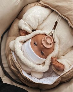 a baby is wrapped in a blanket and wearing a pacifier