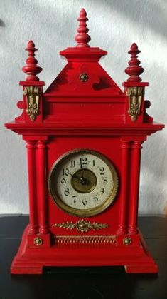 a red clock sitting on top of a table