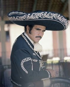 a man wearing a sombrero sitting on top of a chair