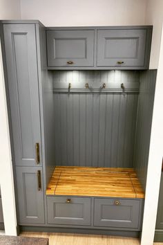 a kitchen with gray cabinets and wooden counter tops