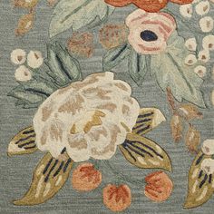 an area rug with flowers and leaves on blue ground, including oranges and pinks