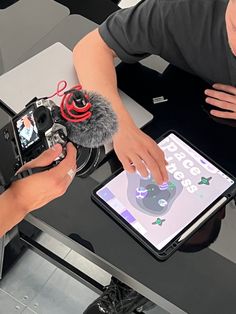 two people sitting at a table with an ipad and microphone in front of them,