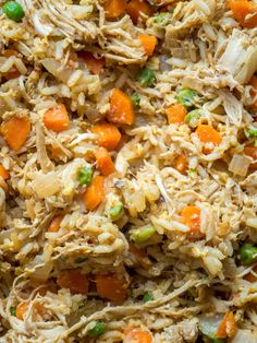 shredded chicken and vegetables in a pan with carrots, celery and peas