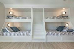 two bunk beds in a room with white walls and wood flooring on the side