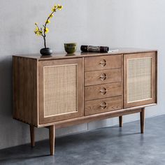 a sideboard with drawers and two vases on top