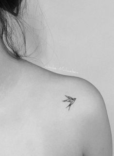 a black and white photo of a woman's shoulder with a small bird on it