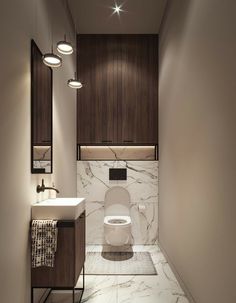 a bathroom with a toilet, sink and mirror in the wall next to it is illuminated by three lights