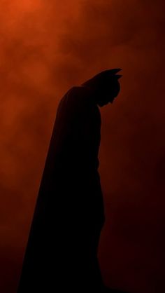 the dark knight silhouetted against an orange sky