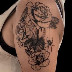 a woman's shoulder with roses and spider web tattoo design on her left arm