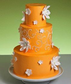 a three tiered cake decorated with flowers and bunting