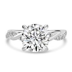 a white gold engagement ring with diamonds on the band and a round cut diamond in the center