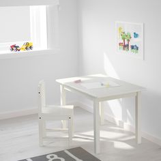 a small white table and chair set in a child's room with a rug on the floor