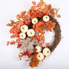 a wreath with orange and white pumpkins on it