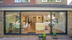 an open living room and kitchen area in a house with brick walls, windows, and doors