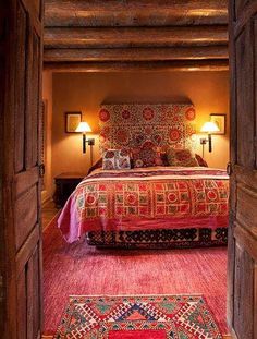 an open door leading to a bedroom with a bed and rugs on the floor