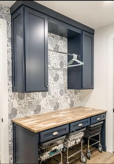 a kitchen with blue cabinets and wooden counter tops