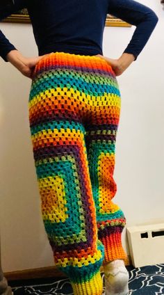 a woman wearing colorful crocheted pants with her hands on her hips