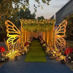 an outdoor garden decorated with flowers and lights for a butterfly themed wedding in the evening