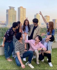 a group of young people standing around each other on top of a grass covered field