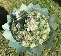 a bouquet of white flowers sitting on top of green paper