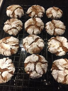 several powdered sugar cookies cooling on a rack