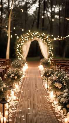 the aisle is lined with candles and decorated with white flowers, greenery and lights