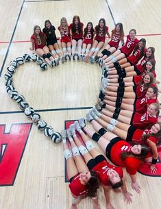 a group of cheerleaders standing in the shape of a heart on a basketball court