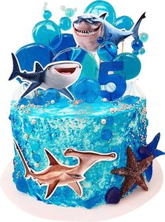 a blue cake with shark decorations on it