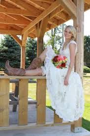 a woman in a white dress is sitting on a bench with her legs crossed and holding a bouquet