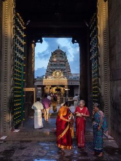 three women standing in front of a temple