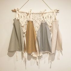 four pieces of clothing hanging on a wall with tassels attached to the side