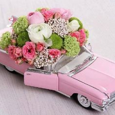 a pink toy car with flowers in the back and writing on the side that says, my girl