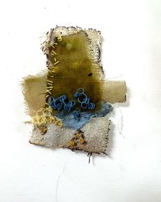 a piece of torn fabric with blue and yellow flowers on it sitting on top of a white surface