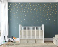 a baby's room with stars painted on the wall and crib next to it