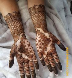 two hands with henna tattoos on them, one is showing the intricate design and the other has an intricate pattern