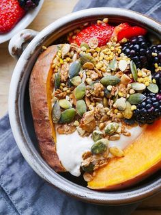 a bowl filled with fruit, nuts and yogurt