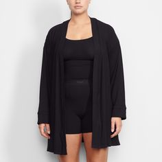 Perfect for lounging and layering over sleepwear, the Soft Lounge Robe is composed of super-soft modal ribbed fabric that drapes effortlessly in all the right places. This short robe features an adjustable self-tie belt and functional side pocket at inseam. | SKIMS Robe | Black | Soft Lounge Spring Lounging Wrap Sleepwear, Open Front Loungewear Outerwear, Fall Loungewear Open Front Robe, Fall Loungewear Robe With Open Front, Casual Oversized Robe For Loungewear, Tie Waist Wrap Sleepwear For Loungewear, Tie Waist Wrap Sleepwear, Wrap Sleepwear With Tie Waist For Loungewear, Relaxed Fit Comfortable Cardigan For Loungewear